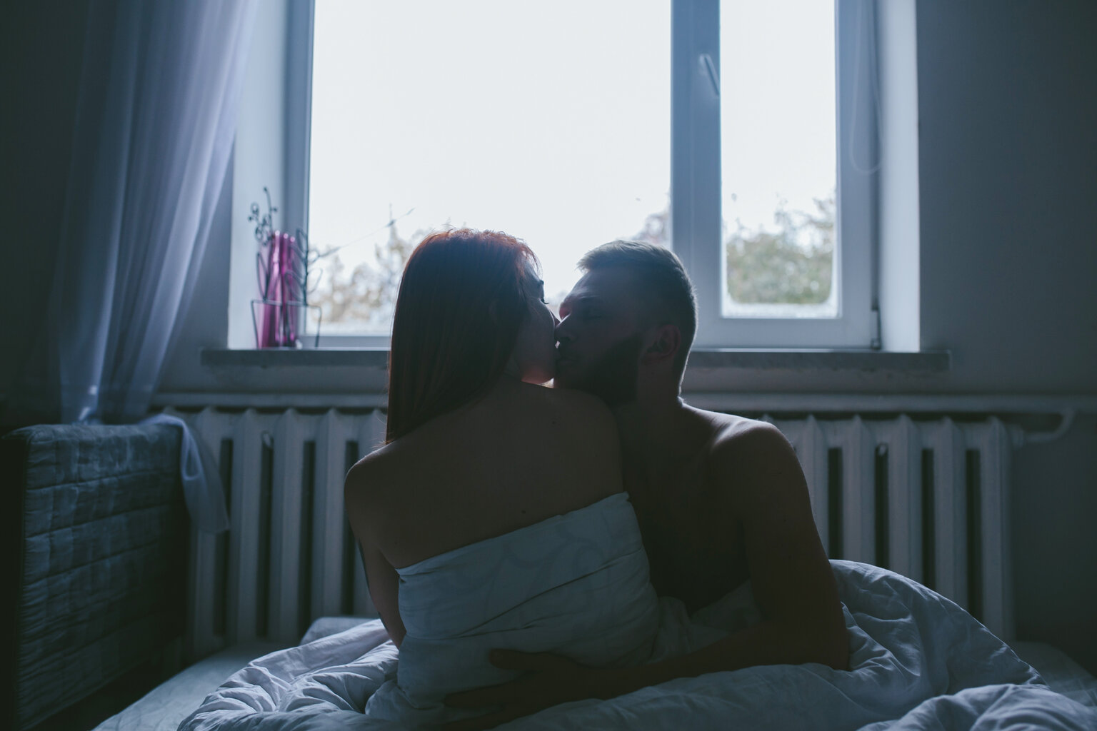 man and woman getting intimate in bed - man and woman kissing -Talkingsex.com