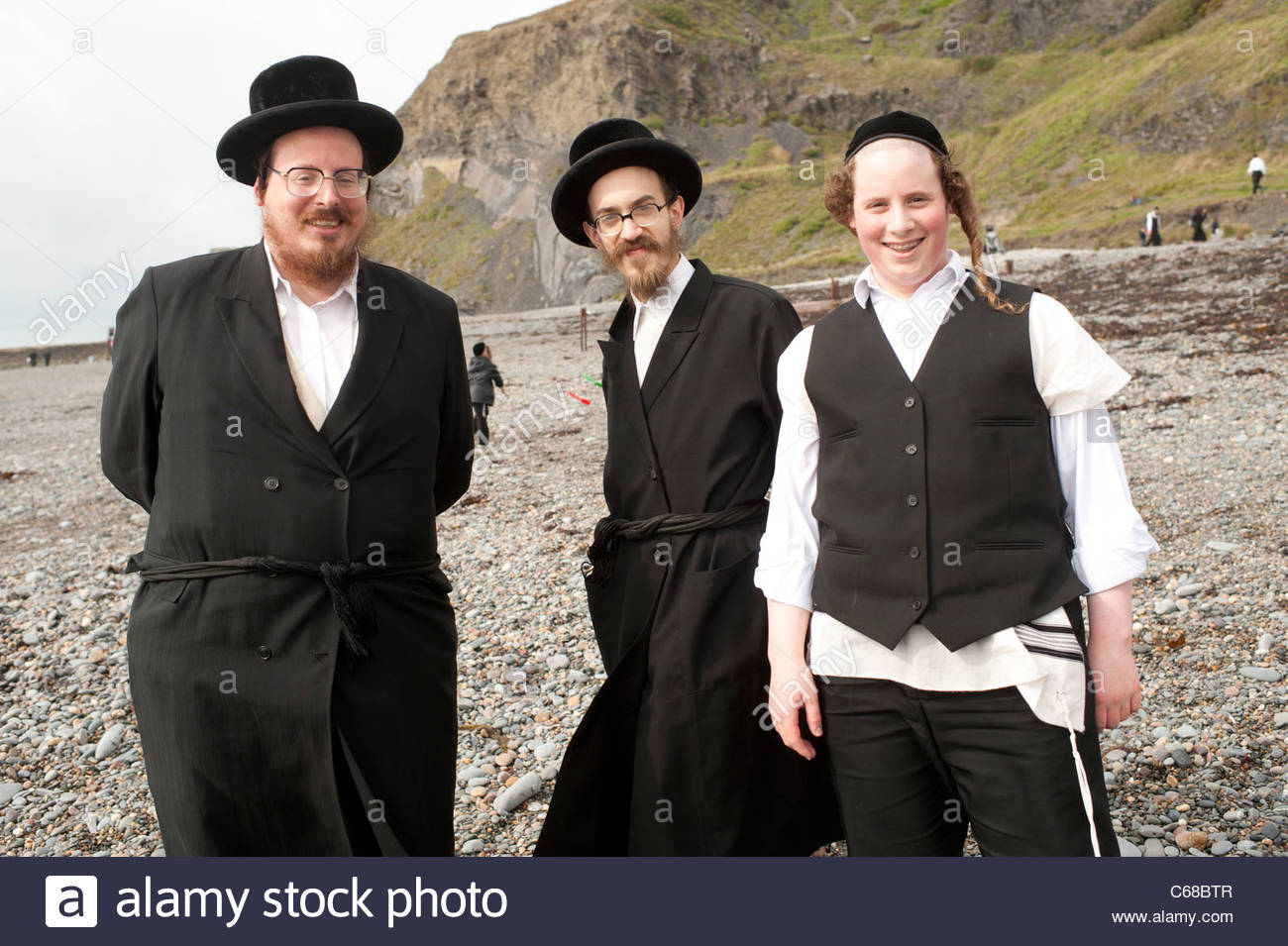 three-male-orthodox-hassidic-jews-on-summer-holiday-on-the-beach-at-C68BTR.jpg