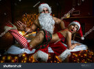 stock-photo-portrait-of-santa-claus-sitting-in-the-bed-with-sexy-girl-in-santa-hats-and-slappi...jpg