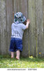 stock-photo-curious-boy-peeks-through-hole-in-fence-to-see-what-is-on-other-side-83677084.jpg
